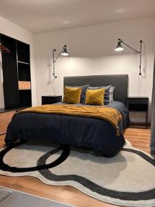 Un dormitorio con una cama con almohadas. en Élégant F2 luxueux proche Suisse, en Delle