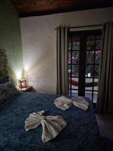duas toalhas numa cama num quarto com uma janela em Canto Verde Pousada em Lençóis