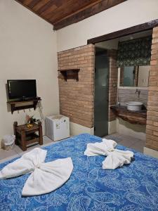 a bedroom with a blue bed with towels on it at Canto Verde Pousada in Lençóis