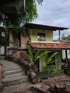 Canto Verde Pousada في لينكويس: منزل أخضر صغير مع درج يؤدي إليه