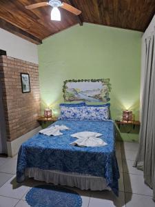 um quarto com uma cama azul com toalhas em Canto Verde Pousada em Lençóis