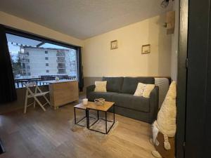 a living room with a couch and a table at *Nouveau* Studio au pied du télésiège du Diable in Les Deux Alpes