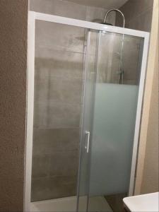 a glass shower door in a bathroom at *Nouveau* Studio au pied du télésiège du Diable in Les Deux Alpes