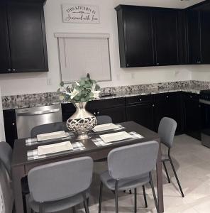 a kitchen with a table with chairs and a vase on it at New, and Modern Home close to the strip in Las Vegas