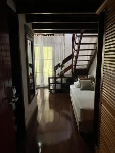 1 dormitorio con 1 cama y suelo de madera en Boutique Hotel Colinas Petrópolis by Ateliê, en Petrópolis