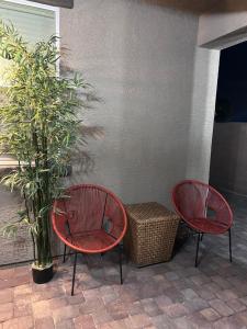 two red chairs and a basket next to a plant at New, and Modern Home close to the strip in Las Vegas
