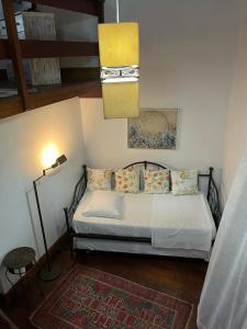 1 dormitorio con cama, lámpara y alfombra en Boutique Hotel Colinas Petrópolis by Ateliê, en Petrópolis