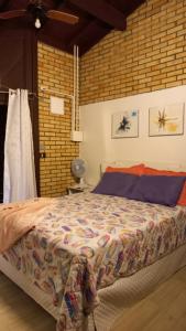 a bedroom with a bed with a brick wall at Casa de 3 Quartos em Garopaba - Bairro Ferraz in Garopaba