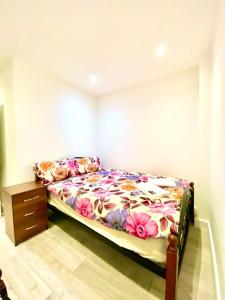 a bedroom with a bed and a dresser at Comfortable One Bedroom Flat With Car Park In London in London