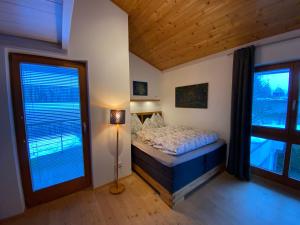 a bedroom with a bed and two large windows at Ferienhaus in Westendorf in Westendorf