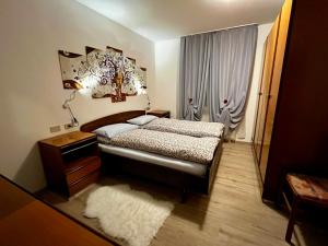 sypialnia z łóżkiem, lampką i oknem w obiekcie My Dolomites Home w mieście Livinallongo del Col di Lana