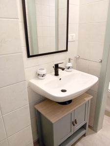 a bathroom with a white sink and a mirror at Petite Maison in Asti