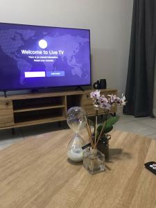 a vase with flowers on a table in front of a tv at Laguna Getaway at The Blyde in Pretoria