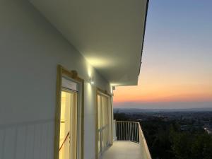 uma varanda com vista para a cidade ao pôr-do-sol em Villa Pasha em Tirana