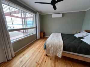 1 dormitorio con 1 cama y ventilador de techo en Bower by the Sea, en Penneshaw