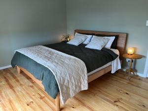 1 dormitorio con 1 cama grande y suelo de madera en Bower by the Sea, en Penneshaw