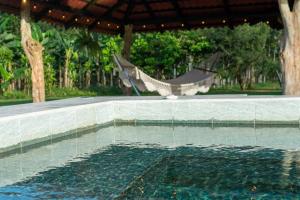 a swimming pool with a hammock in a resort at Casa Roble Fortuna in Fortuna