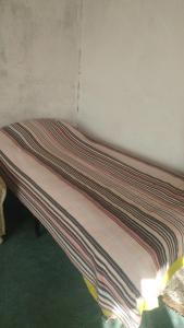a bed in a room with a striped blanket on it at enesin evi in Kayseri
