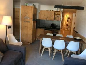 a living room with a table and white chairs at Appartement Central avec Piscine, Proche Remontées et Multi Pass Inclus à Châtel - FR-1-693-105 in Châtel