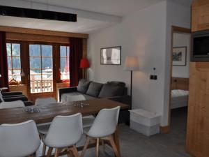 a living room with a table and chairs and a couch at Appartement Central avec Piscine, Proche Remontées et Multi Pass Inclus à Châtel - FR-1-693-105 in Châtel