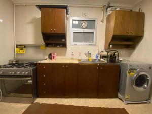 a kitchen with a stove and a washing machine at Lovely 3 Bedrooms Apartment in Madinaty