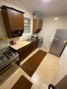 a small kitchen with a stove and a refrigerator at Lovely 3 Bedrooms Apartment in Madinaty +4 photos