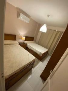 ein kleines Zimmer mit 2 Betten und einer Lampe in der Unterkunft Lovely 3 Bedrooms Apartment in Madinaty + 4 Fotos