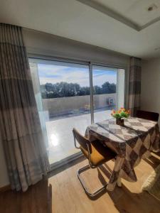 a dining room with a table and a large window at Jasmine Studio coquette in Nabeul