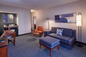 a living room with a couch and a chair at Courtyard Detroit Metro Airport Romulus in Romulus