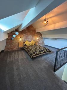 a bedroom with a bed in a brick wall at Cottage in Holmfirth Centre in Holmfirth