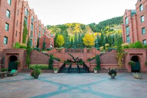 a courtyard with stairs between brick buildings with trees at St. Regis Aspen Resort in Aspen