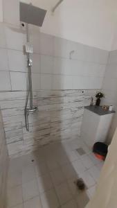 a bathroom with a shower and a tile floor at Doña Rita departamentos in Villa María