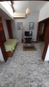 a living room with a bed and a tv at Doña Rita departamentos in Villa María