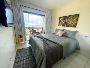a bedroom with a bed with a view of a balcony at Flat Condomínio Monte Castelo Gravatá in Bezerros