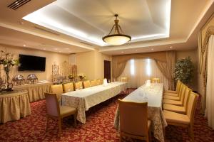 TOSCANA INN HOTEL في مدينة باناما: قاعة اجتماعات مع طاولتين وكراسي وتلفزيون