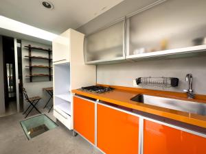 uma cozinha com armários laranja e branco e um lavatório em Loft 2 cuartos Terraza y baño privados em Cidade do México
