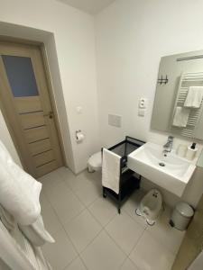 a white bathroom with a sink and a mirror at Apartmány Mýtinka - Jeseníky in Jeseník