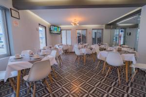 a dining room with white tables and white chairs at Expo Hotel Guadalajara - Zona Expo frente al Centro de Convenciones in Guadalajara