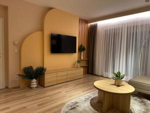 Una sala de estar con un televisor de pantalla plana en una pared. en Top-Apartments, en Pristina