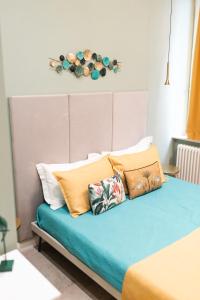ナポリにあるB&Bio Architielloのカラフルな枕が付いたベッド1台が備わる客室です。