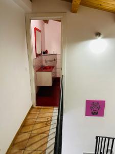 a hallway leading to a bathroom with a red sink at Cartari Apartment in Palermo