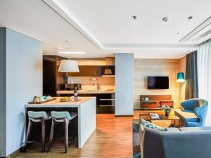 釜山Haeundae Wide Ocean View & Residence的配有桌椅的厨房和客厅