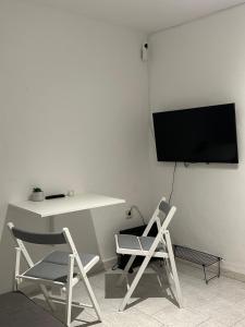 Una habitación con dos sillas y una mesa y un televisor. en Vientos de Alcornoque, en Alcalá de los Gazules 8 fotos más