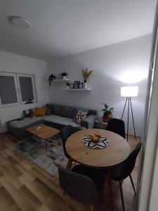 uma sala de estar com um sofá e uma mesa em Jaz Apartman em Bajina Bašta