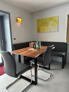 a dining room with a wooden table and chairs at WPA Apartments - Zimmer- Modernes Apartment mit Parkplatz,WiFi,Netflix in Moosthenning