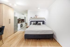 1 dormitorio con 1 cama grande y cocina en Zoder Apartments, en Viena