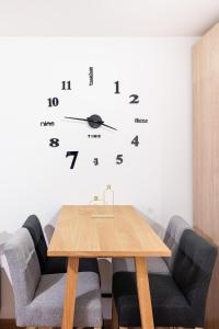 a table and chairs with a clock on the wall at Zoder Apartments in Vienna
