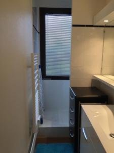 une petite salle de bain avec un lavabo et une fenêtre dans l'établissement Immeuble Lauvitel - Apt Comme à la Maison- Front de Neige Plein Sud, à Les Deux Alpes 6 autres photos