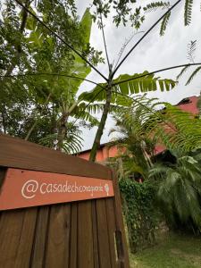 un cartel en una valla de madera delante de un árbol en CASA DE CHICO, en Guarda do Embaú