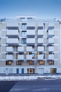 un edificio de apartamentos en la nieve con un árbol delante en Zoder Apartments, en Viena